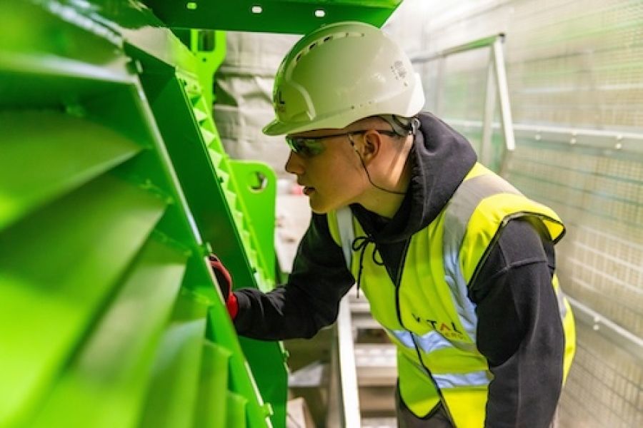 Person with hard hat working in a paper factory 
