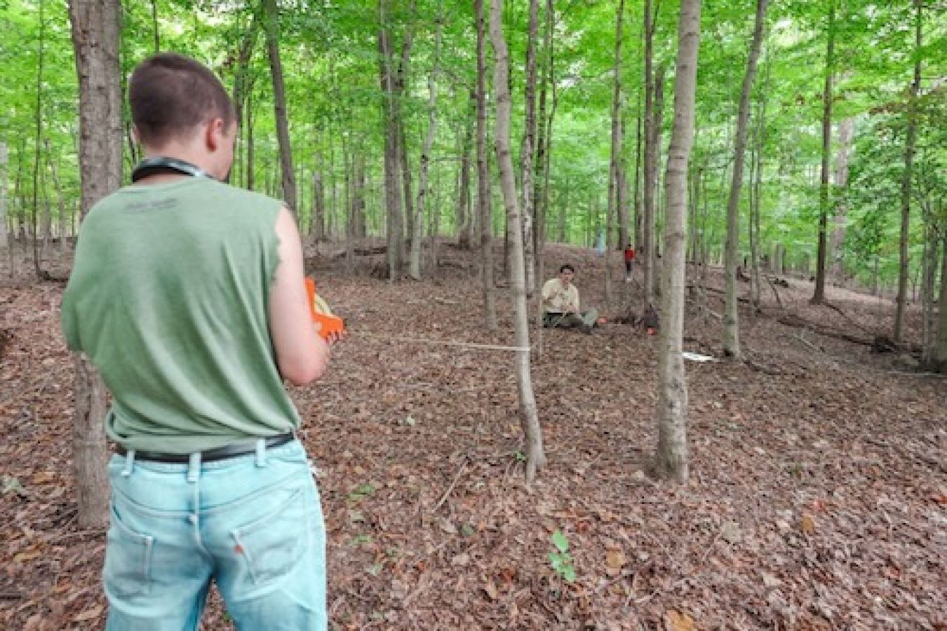 Two people outdoors taking the canopy measurement. 