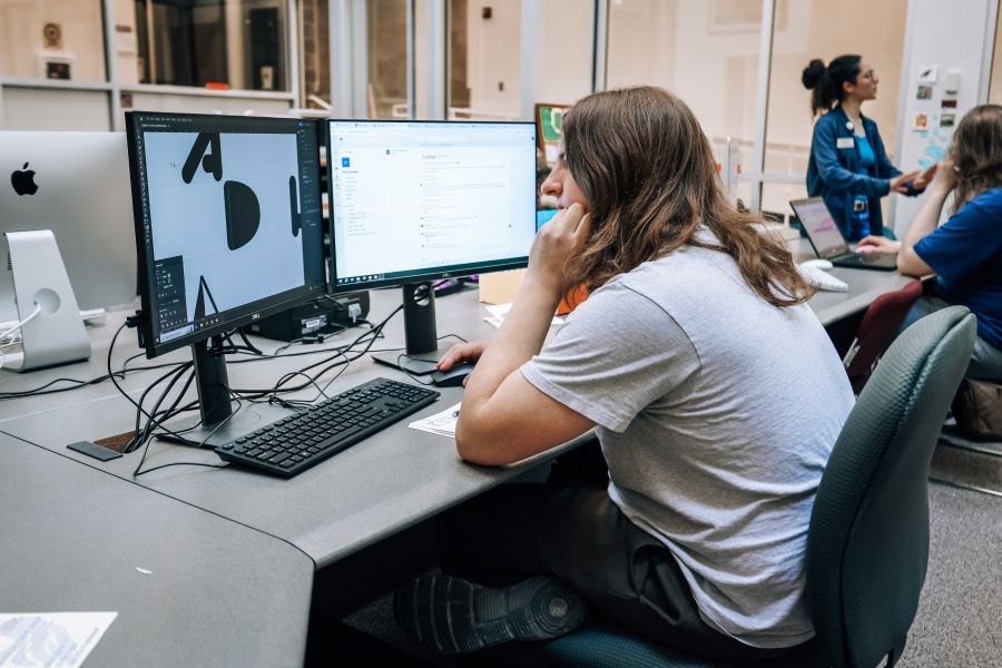 Person sitting at a computer and working with a design program. 