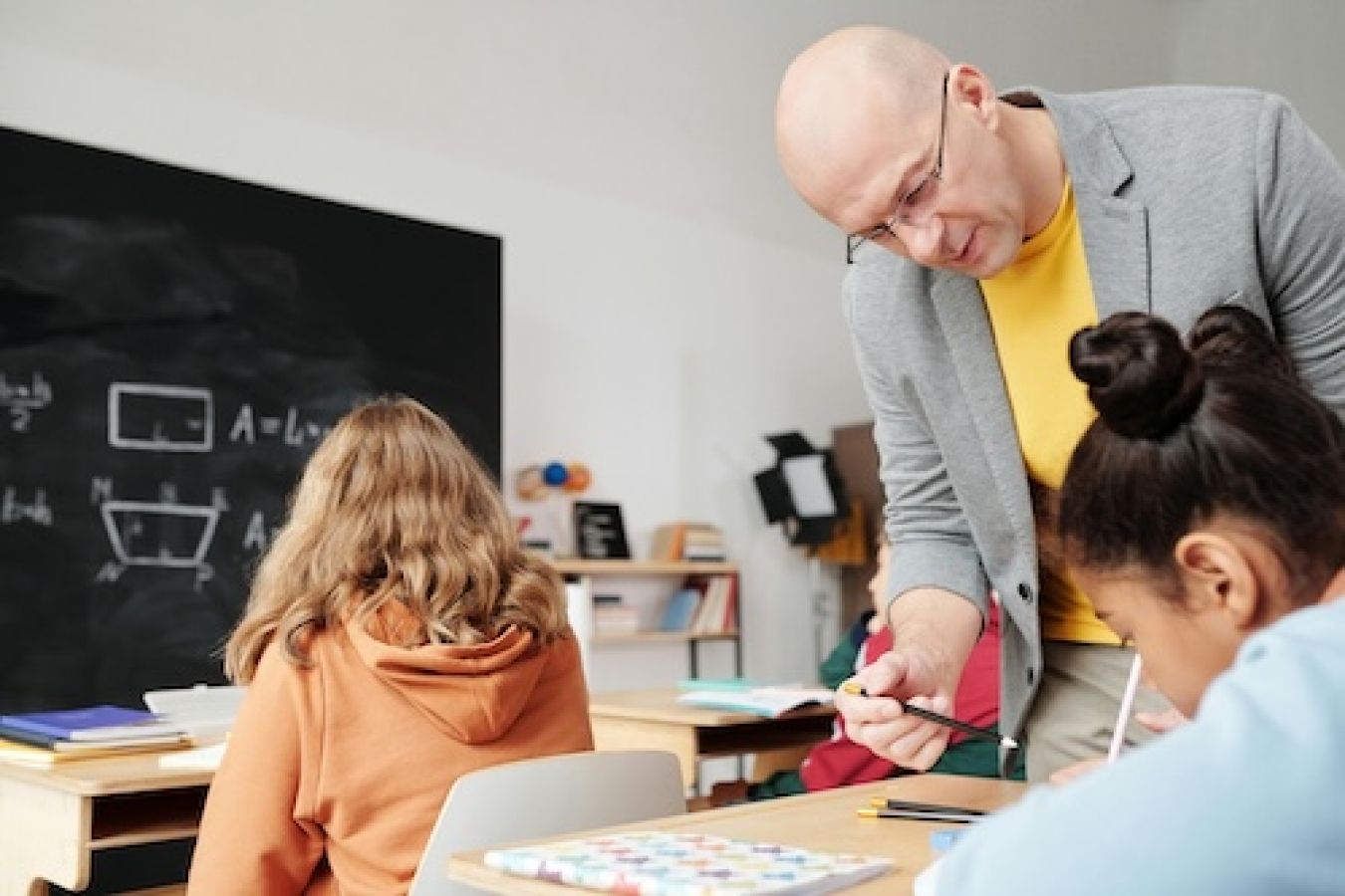 teacher working with a student in the classroom. 