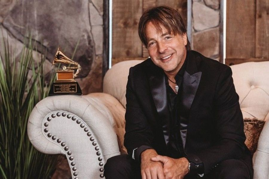 Lonnie Park sitting with a Grammy award