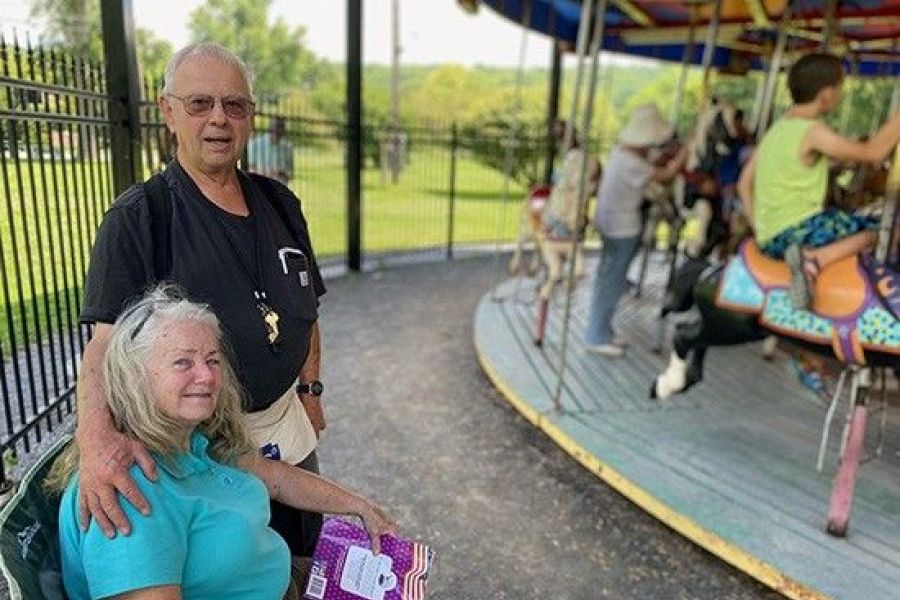 Alice Jane and Phil Munson next to carousel
