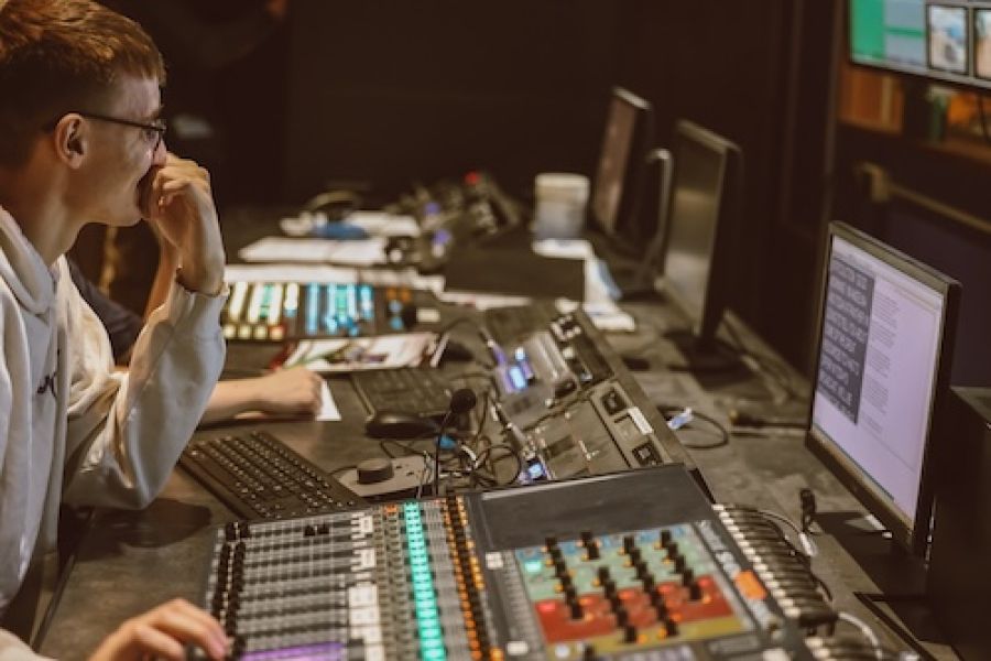 person at switchboard and looking at a screen. 