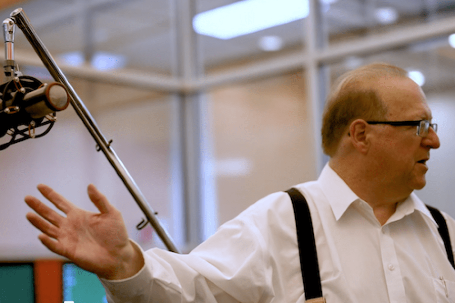 Teacher gesturing to a professional microphone 